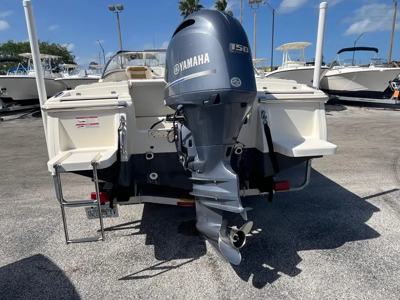 Slide: The Image of 2018 Scout 210 Dorado boat with Yamaha 150 outboard motor, parked on a sunny day. - 5