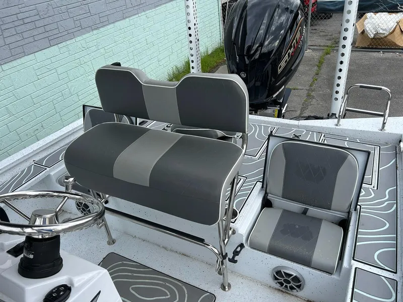 Slide: The Image of 2024 Express X23 Bay Lounge boat interior with gray seating and steering wheel. - 11