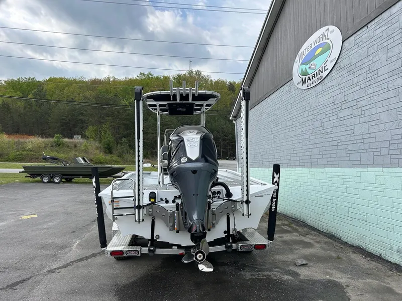 Slide: The Image of 2024 Express X23 Bay Lounge boat parked outside a marine shop. - 5