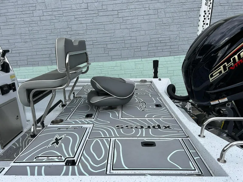 Slide: The Image of 2024 Express X23 Bay Lounge boat deck with seating and motor, featuring modern design elements. - 6