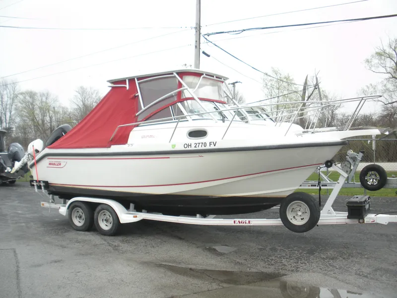 Slide: The Image of 1998 Boston Whaler 23 Conquest boat on trailer with red canopy, parked outdoors. - 0