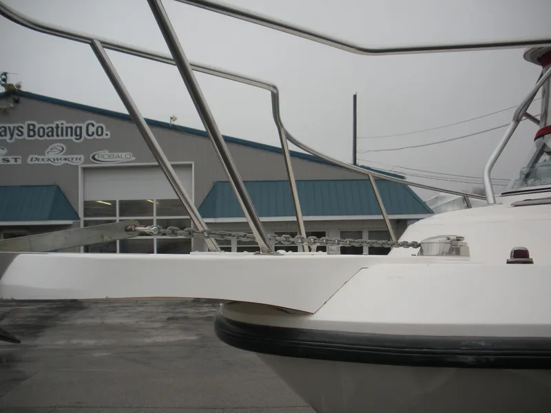 Slide: The Image of 1998 Boston Whaler 23 Conquest boat at a marina, showcasing bow and railings. - 1
