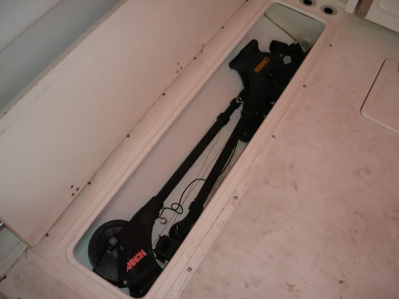 Slide: The Image of Storage compartment on a 1998 Boston Whaler 23 Conquest boat, featuring fishing equipment. - 13