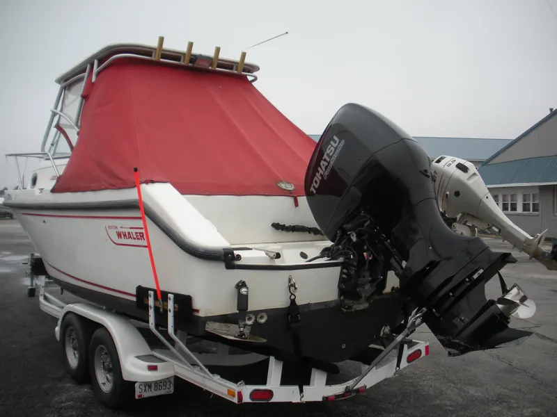 Slide: The Image of 1998 Boston Whaler 23 Conquest boat with red cover and Tohatsu outboard motor on trailer. - 14