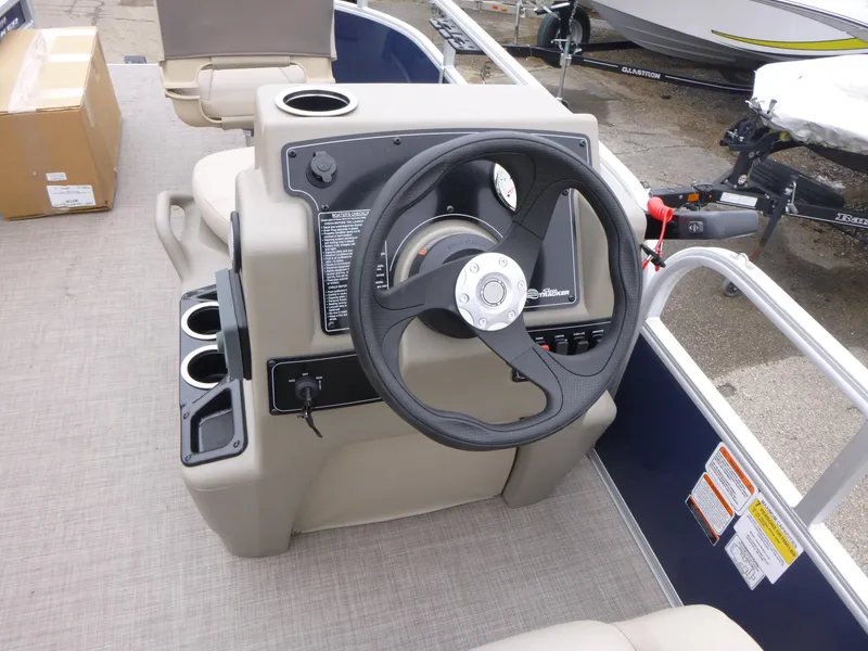 Slide: The Image of 2025 Sun Tracker Bass Buggy 16 XL Select steering console with cup holders and controls. - 6