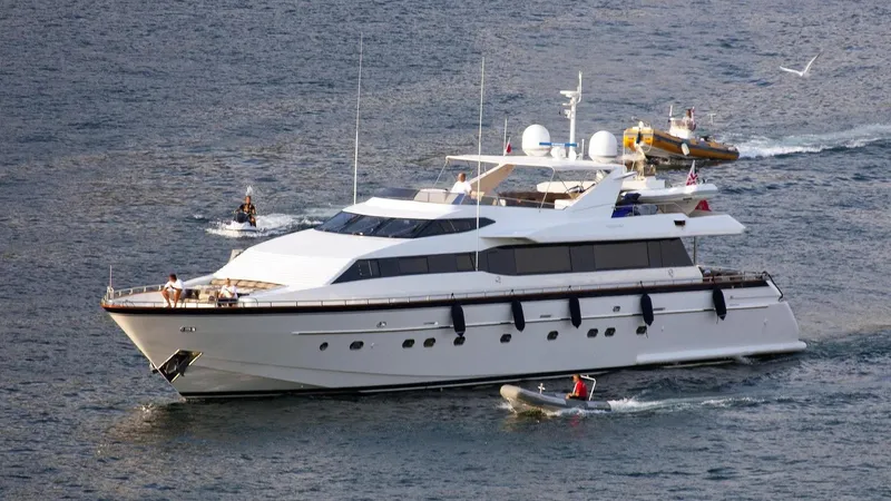 The Image of Luxurious 2001 Falcon 106 yacht cruising with escort boats on open water. - 0