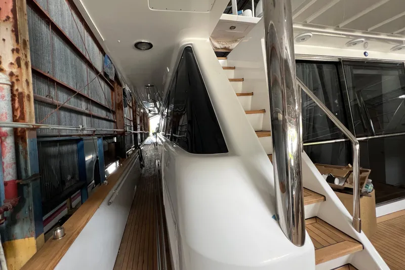 Slide: The Image of Side view of a 2001 Falcon 106 yacht with wooden deck and stairs. - 14