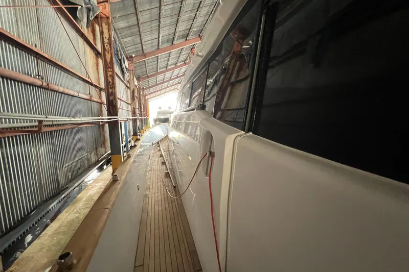 Slide: The Image of Side view of a 2001 Falcon 106 yacht in a metal-roofed dock. - 16
