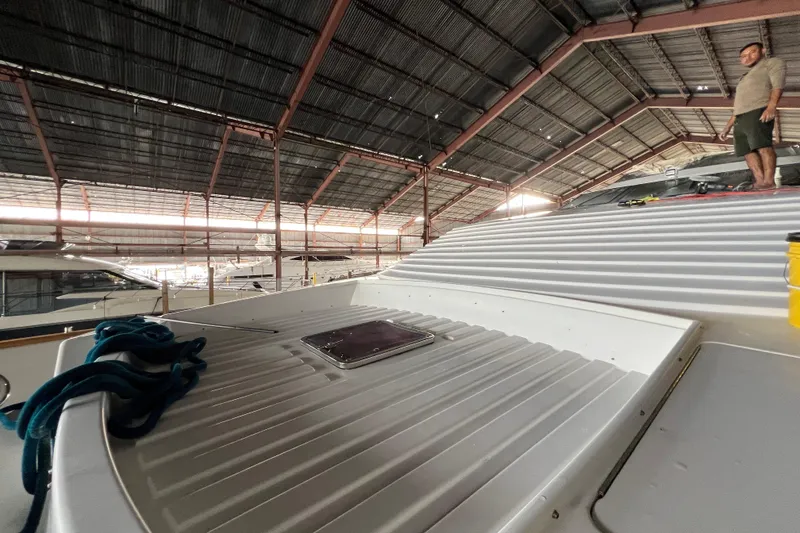 Slide: The Image of Indoor view of a 2001 Falcon 106 yacht under maintenance in a spacious boatyard. - 18