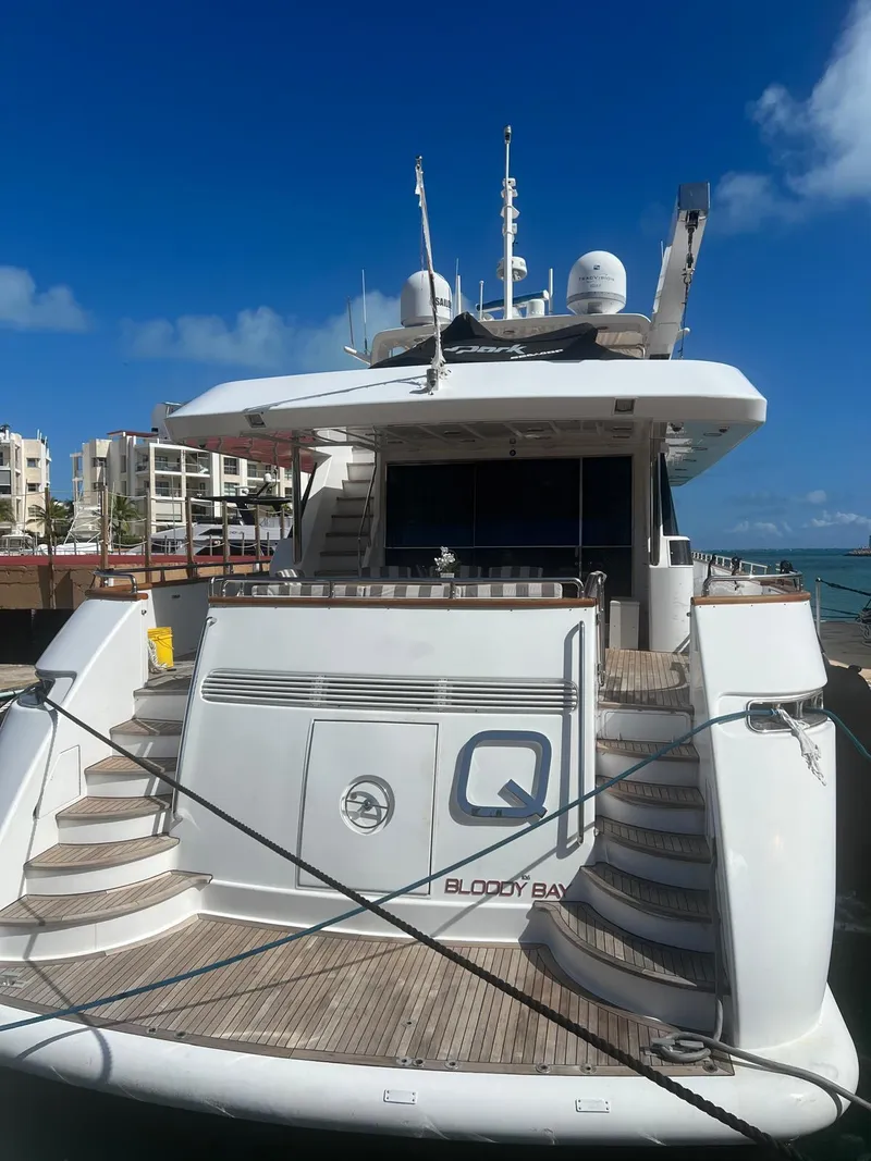 Slide: The Image of Luxury Falcon 106 yacht docked at marina, 2001 model, clear blue sky background. - 2