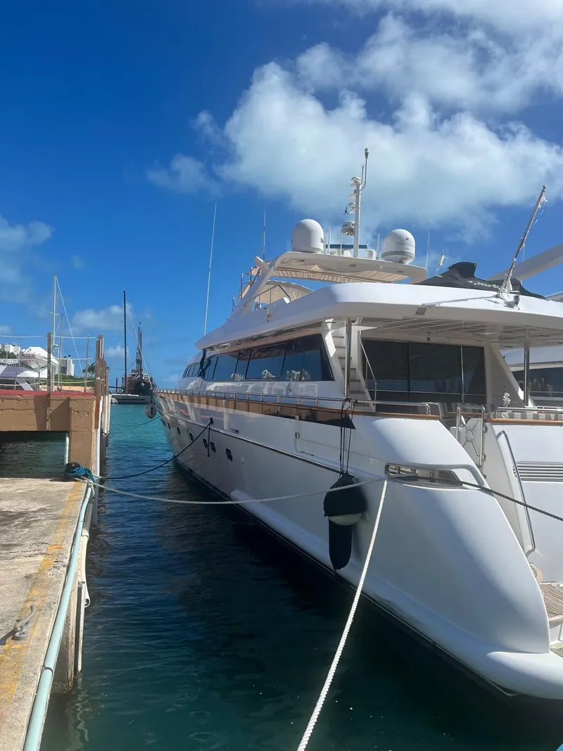 Slide: The Image of Luxury Falcon 106 yacht docked at marina under clear blue sky, 2001 model. - 4