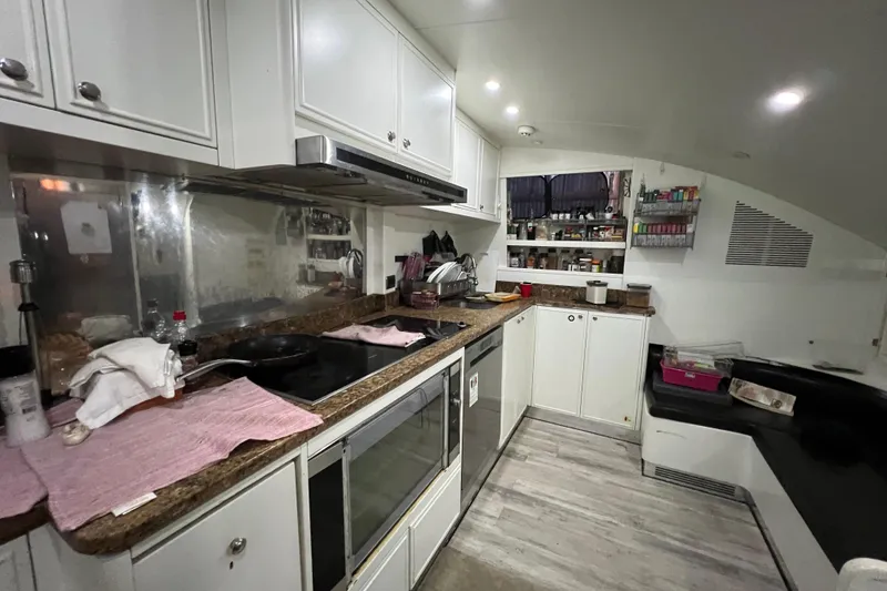 Slide: The Image of Compact kitchen interior on a 2001 Falcon 106 yacht, featuring modern appliances and storage. - 43