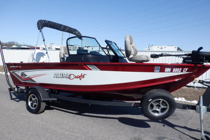 Slide: The Image of 2020 Alumacraft Competitor 165 Sport boat on trailer, red and white design, outdoor setting. - 1