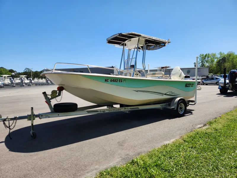Slide: The Image of 2018 Carolina Skiff 218 DLV boat on trailer, parked outdoors under clear sky. - 7
