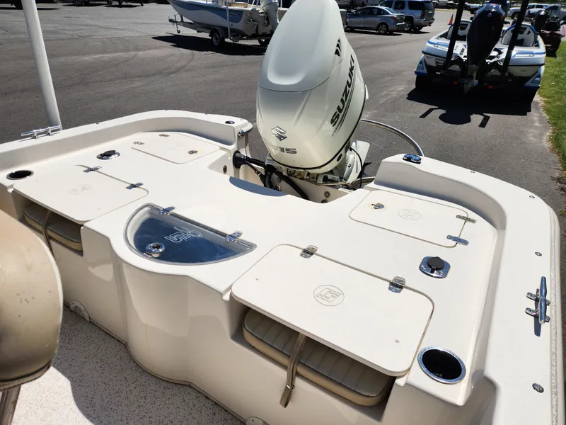 Slide: The Image of 2018 Carolina Skiff 218 DLV boat with Suzuki outboard motor, featuring spacious deck layout. - 9