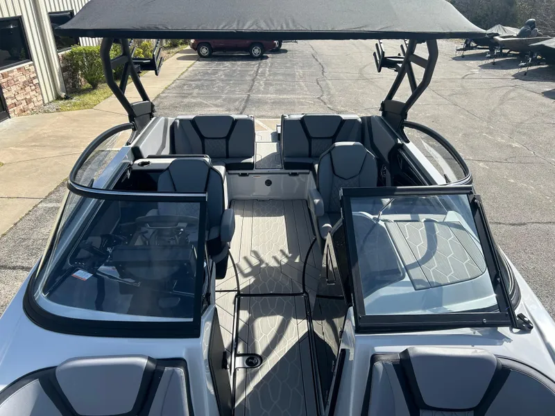 Slide: The Image of 2025 Yamaha Boats 255XD interior with seating and canopy, docked outdoors. - 2