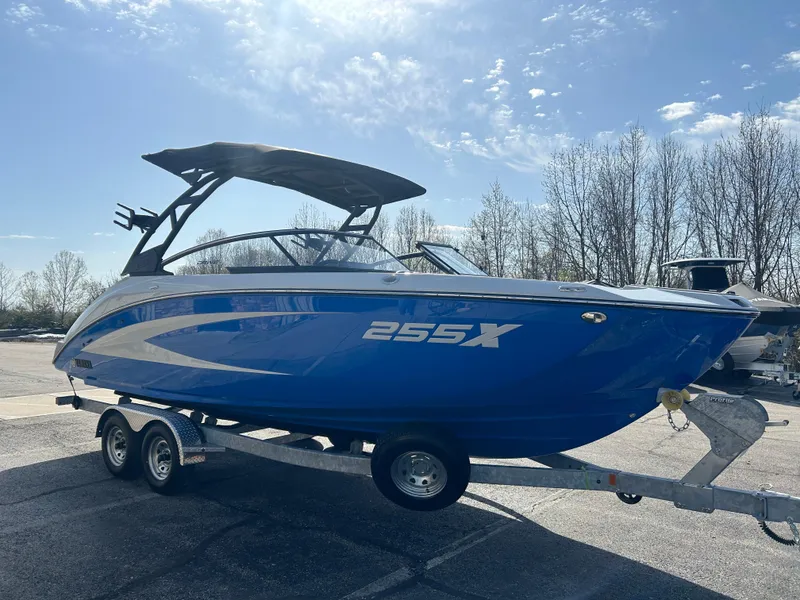 Slide: The Image of 2025 Yamaha Boats 255XD in blue on a trailer, parked outdoors. - 3