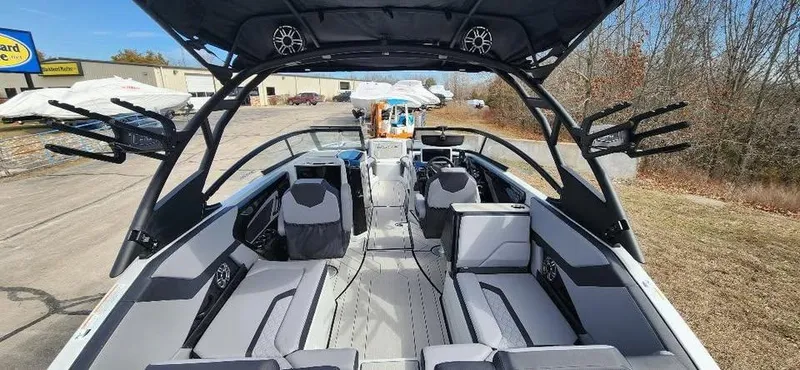 Slide: The Image of 2025 Yamaha Boats 255XD interior with seating and speakers, parked outdoors. - 7