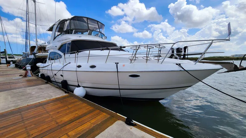Slide: The Image of Luxury 2002 Cruisers 5000 yacht docked at marina under blue sky. - 1