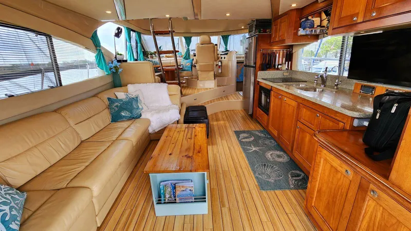 Slide: The Image of Luxurious 2002 Cruisers 5000 yacht interior with leather seating, wooden cabinetry, and modern kitchen amenities. - 17