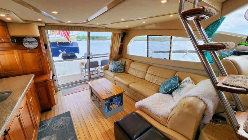 Slide: The Image of Luxurious 2002 Cruisers 5000 yacht interior with leather seating, wooden cabinetry, and scenic water views. - 19