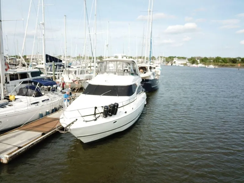 Slide: The Image of 2002 Cruisers 5000 yacht docked at marina with other boats. - 2