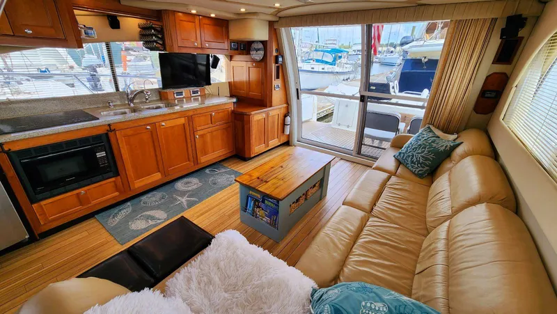 Slide: The Image of Luxurious 2002 Cruisers 5000 yacht interior with kitchen, leather seating, and marina view. - 20