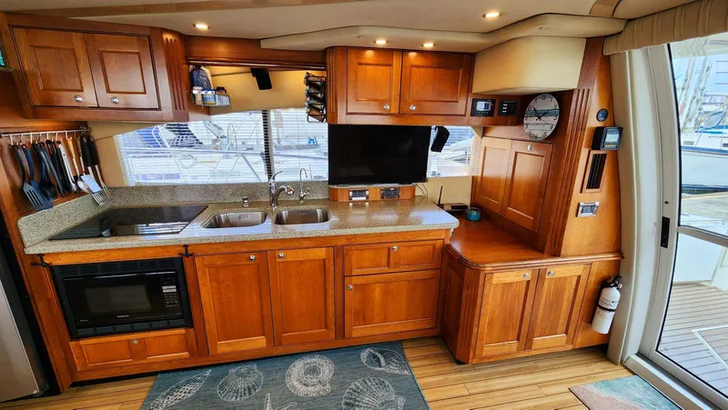Slide: The Image of Luxurious 2002 Cruisers 5000 yacht kitchen with wooden cabinets and modern appliances. - 21