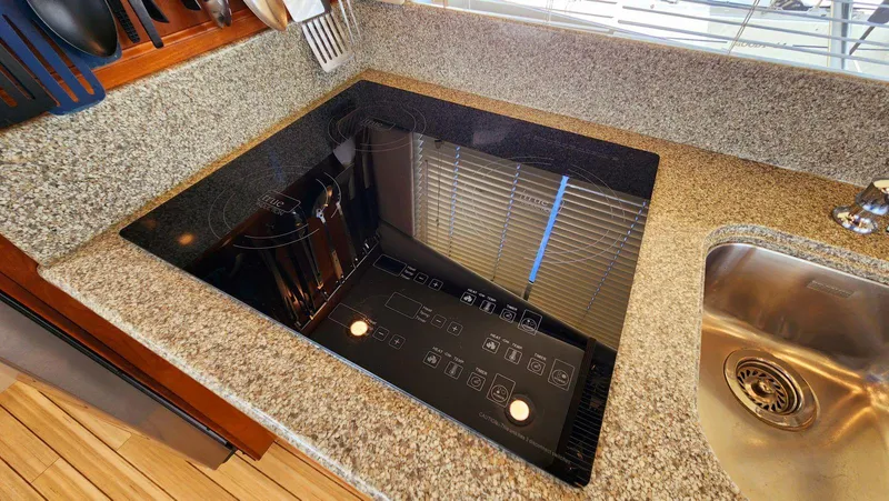 Slide: The Image of Modern kitchen cooktop on granite countertop in a 2002 Cruisers 5000 yacht. - 27