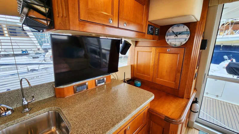 Slide: The Image of Interior of 2002 Cruisers 5000 yacht with wood cabinetry, TV, and clock. - 28