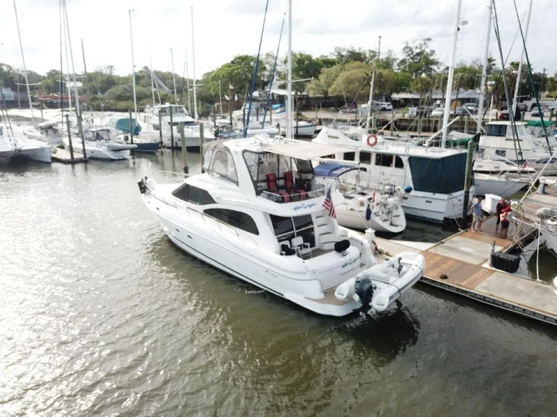 Slide: The Image of 2002 Cruisers 5000 yacht docked at marina, surrounded by other boats. - 3
