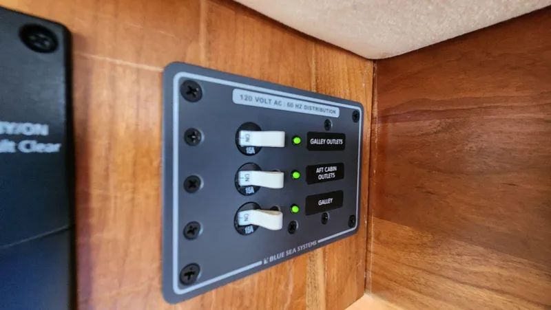 Slide: The Image of Electrical panel on 2002 Cruisers 5000 yacht, featuring 120V AC distribution switches. - 30