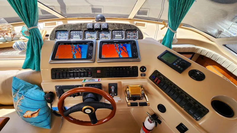 Slide: The Image of Helm of 2002 Cruisers 5000 yacht with navigation screens and controls. - 35