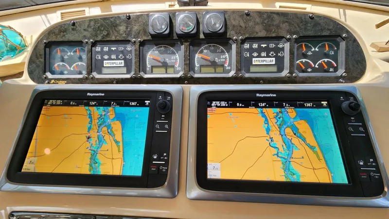 Slide: The Image of Dashboard of a 2002 Cruisers 5000 yacht with navigation screens and gauges. - 36