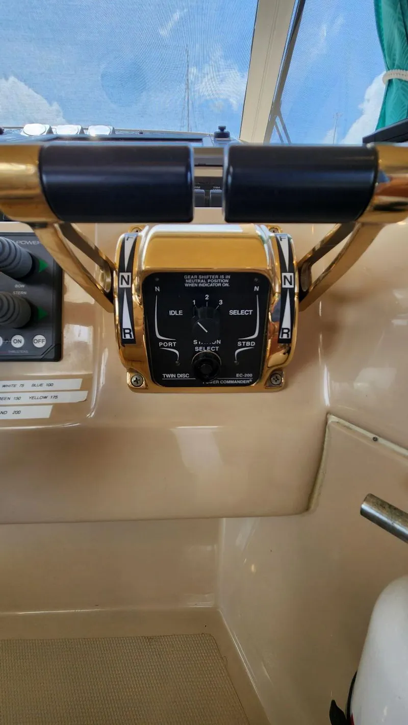 Slide: The Image of Control panel of a 2002 Cruisers 5000 yacht, featuring throttle and gear levers. - 42