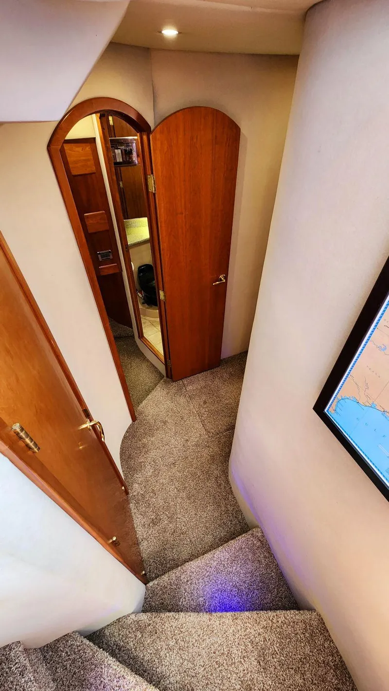 Slide: The Image of Interior of 2002 Cruisers 5000 yacht, featuring carpeted stairs and wooden doors. - 48