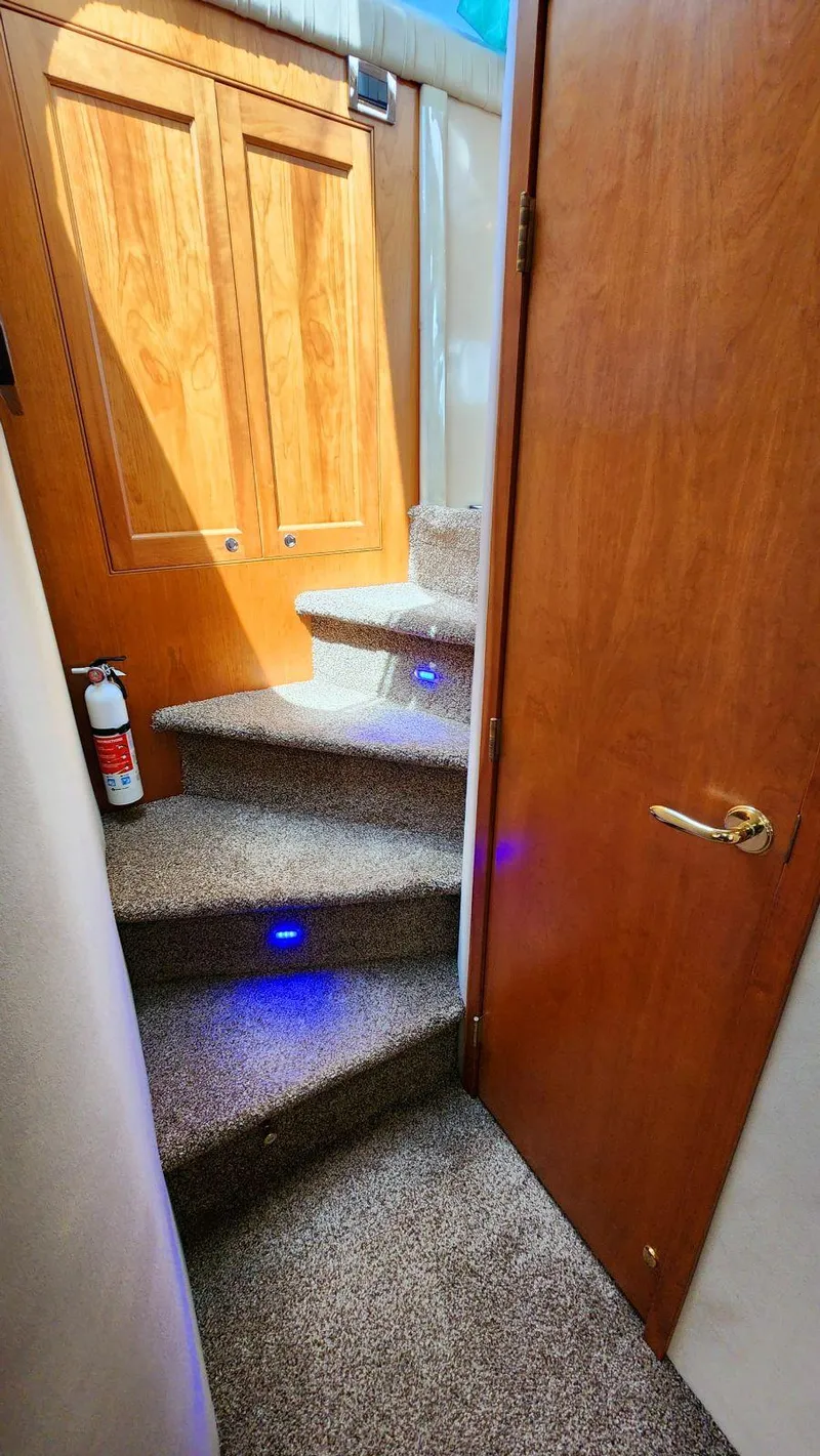 Slide: The Image of Staircase in 2002 Cruisers 5000 yacht with carpet and wooden door. - 49