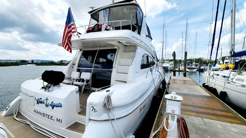 Slide: The Image of Luxury 2002 Cruisers 5000 yacht docked at marina with American flag. - 5