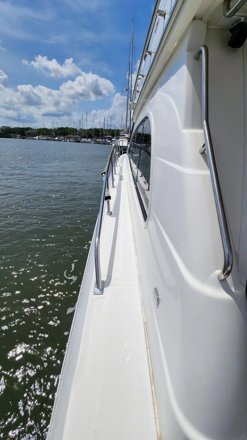 Slide: The Image of 2002 Cruisers 5000 yacht side view on calm water under blue sky. - 9