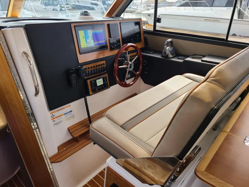 Slide: The Image of 2023 Cutwater C-30 Sedan NW Edition helm with navigation screens and steering wheel. - 10