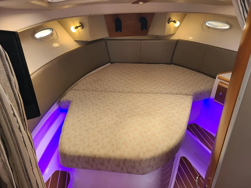 Slide: The Image of 2023 Cutwater C-30 Sedan NW Edition cabin with cozy bed and ambient lighting. - 18