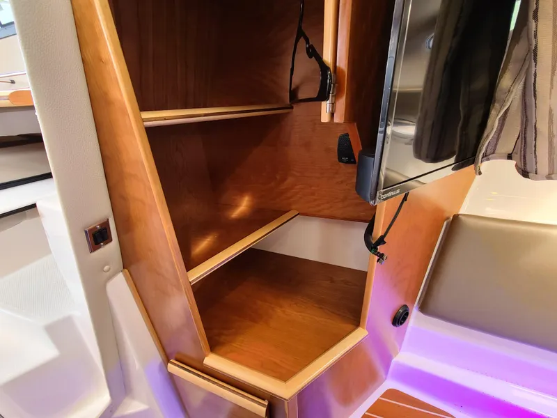 Slide: The Image of 2023 Cutwater C-30 Sedan NW Edition interior with wooden storage shelves and modern design. - 22