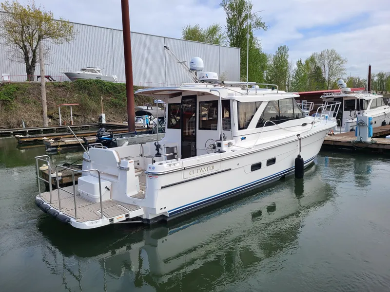 Slide: The Image of 2023 Cutwater C-30 Sedan NW Edition boat docked in a marina. - 4