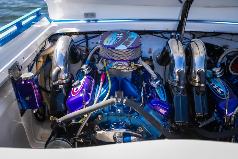 Slide: The Image of Engine of a 2000 Cigarette 38' Top Gun boat, featuring vibrant blue and chrome components. - 10