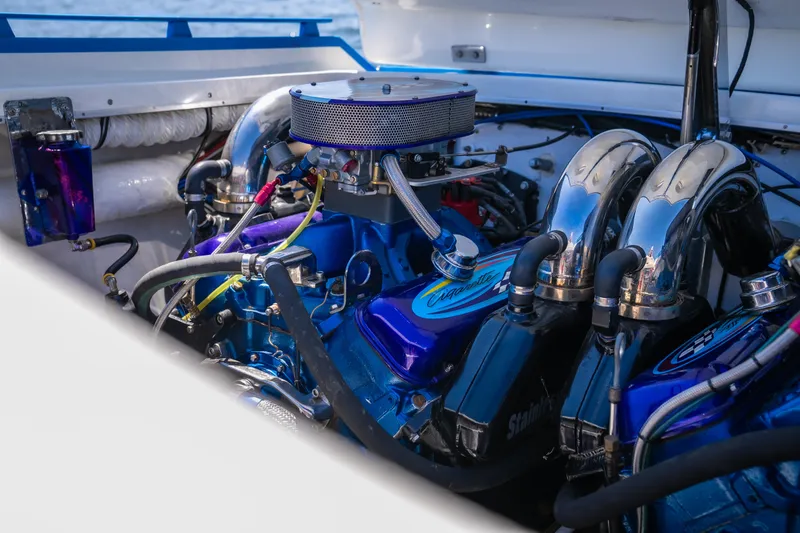 Slide: The Image of Engine of a 2000 Cigarette 38' Top Gun boat, showcasing chrome and blue components. - 11