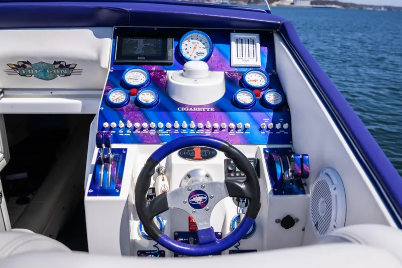 Slide: The Image of Cockpit of a 2000 Cigarette 38' Top Gun boat with vibrant gauges and controls. - 14
