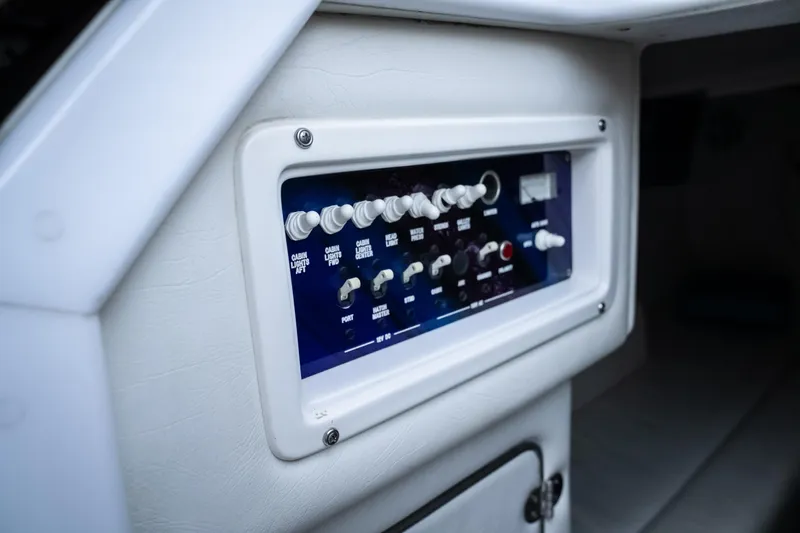 Slide: The Image of Control panel of a 2000 Cigarette 38' Top Gun boat, featuring various switches and dials. - 24
