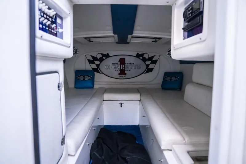 Slide: The Image of Interior of 2000 Cigarette 38' Top Gun boat with white seating and control panels. - 26