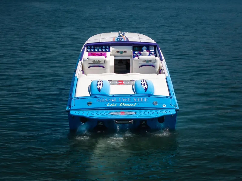 Slide: The Image of 2000 Cigarette 38' Top Gun boat on water, vibrant blue and white design. - 6