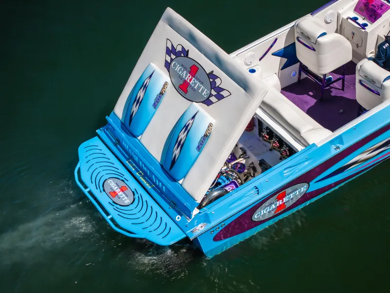Slide: The Image of 2000 Cigarette 38' Top Gun speedboat with vibrant blue and purple interior on water. - 8